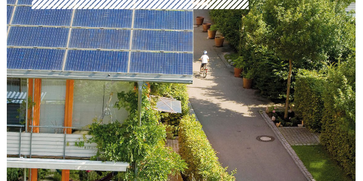 Titelseite der Broschüre "Klimaschutzmanagement und Treibhausgasneutralität in Kommunen: Große Potentiale wirksam erschließen" mit dem Titelbild einer Wohnsiedlung mit Photovoltaik-Dächern, unten das Logo des Umweltbundesamtes