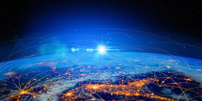 Weltkugel von oben bei Nacht mit beleuchteten Arealen, zwischen denen Verbindungen gezogen sind