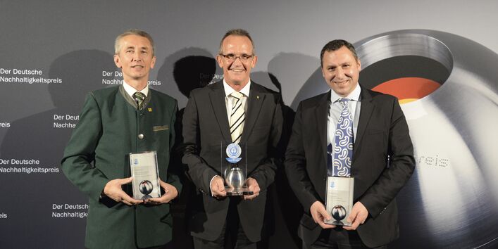 three man holding a "Blue Angel Award" trophy in their hands
