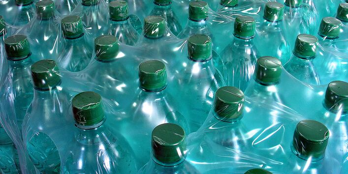 eine riesige Menge Plastikflaschen mit Mineralwasser, die wiederum zu mehreren in Plastikfolie eingeschweißt sind