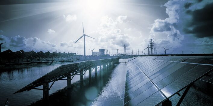 in einer futuristisch anmutenden Szenerie mit blauem Licht stehen Solarpanels auf einer Wasserfläche, im Hintergrund Windkraftanlagen und Strommasten