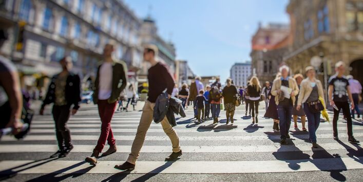 Fußgängerinnen und Fußgänger auf einem breiten Zebrastreifen in der Sadt