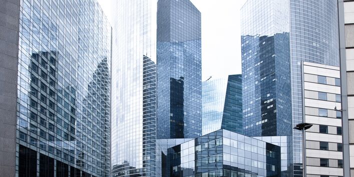 Hochhausviertel mit spiegelnden Fassaden und Straßenschluchten ohne Bäume