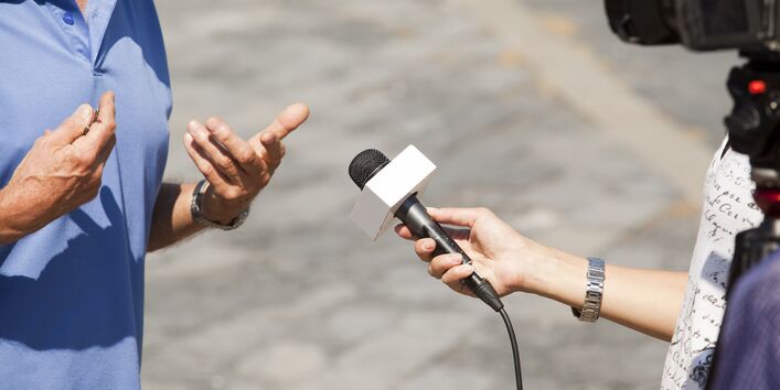 Mann wird interviewt und gefilmt