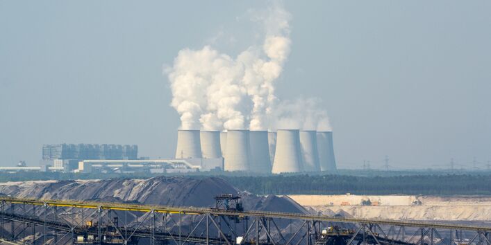 Braunkohletagebau und Kraftwerk mit dampfenden Kühltürmen