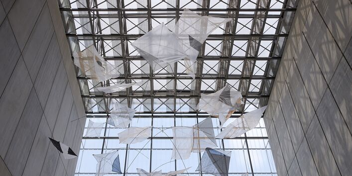 großes Mobile an der Decke eines hohen, modernen Gebäudes mit Glasdach