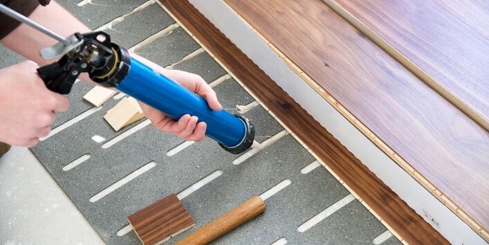 ein Fertigparkett oder -Laminat wird verlegt, dazu wird auf einer Trittschalldämmung ein Klebstoff aufgebracht 