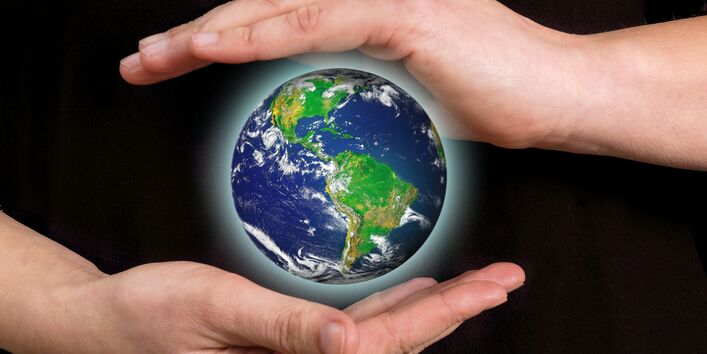 zwei Hände beschützen den Planet Erde