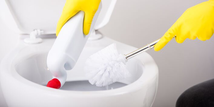 eine Toilette wird geputzt