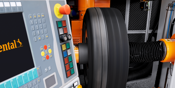 ein Lkw-Reifen ist in eine Maschine eingespannt, daneben ein Bedienpult mit vielen Knöpfen und einem Display