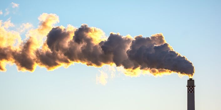 aus einem Schornstein kommen Abgaswolken