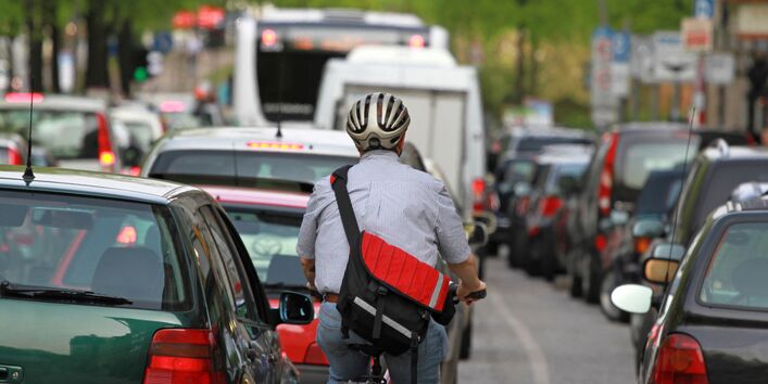 Radfahrer zwischen Autos im Stau