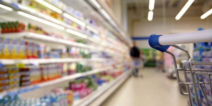ein Gang in einem Supermarkt entlang eines Kühlregals