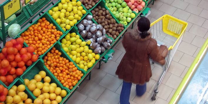 Frau im Supermarkt vor Obstregal