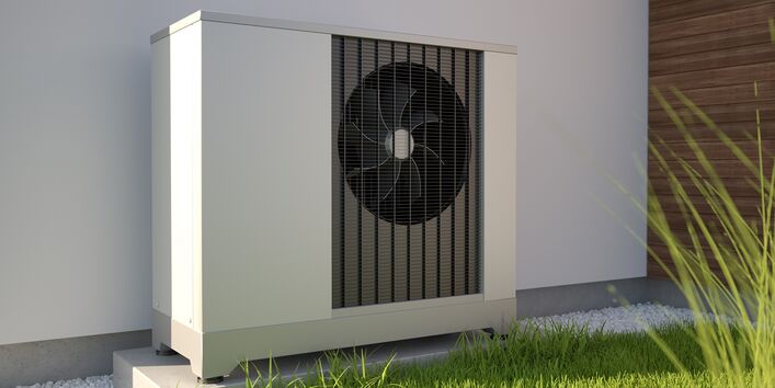 Aggregat einer Wärmepumpe vor einer Hausfassade