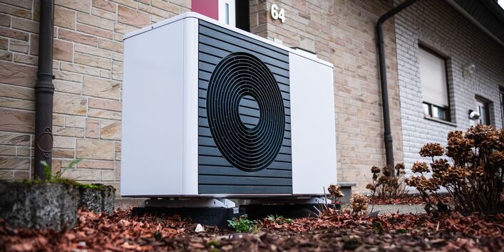 Außeneinheit einer Wärmepumpe im Vorgarten eines Reihenhauses