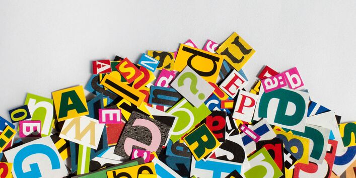 Bunte, aus Zeitschriften ausgeschnittene Buchstaben liegen auf einem Haufen