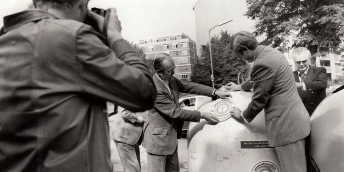 1978 stellt Präsident Heinrich von Lersner den lärmgeminderten Blauer-Engel-Altglascontainer vor