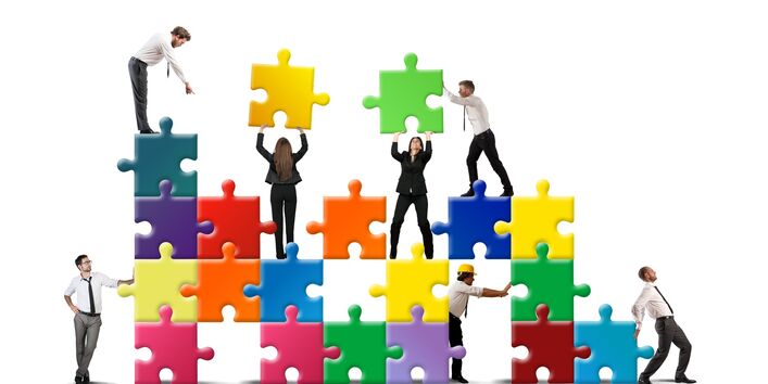 Figuren bauen ein Unternehmen aus Puzzelteilen auf