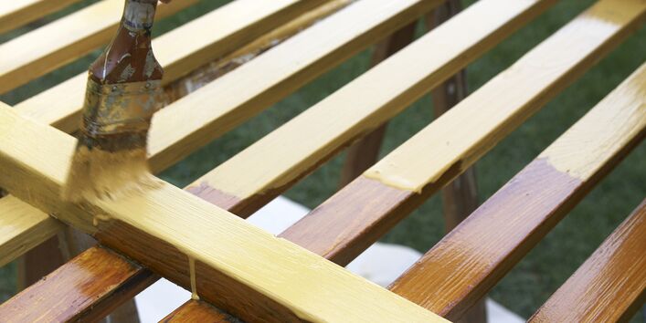 Gartenzaun wird mit einer helleren Farbe angestrichen.