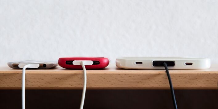 Drei Smartphones am Ladekabel