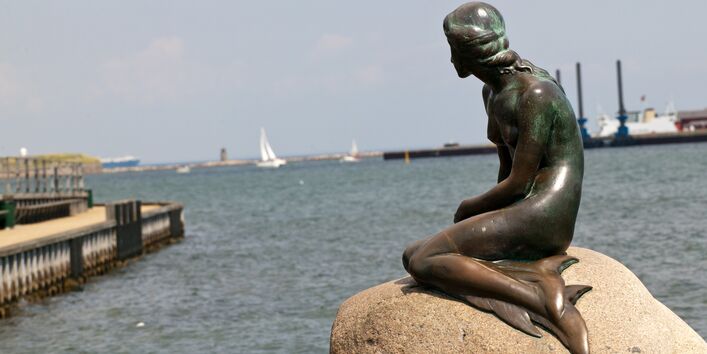 The "Little Mermaid" bronze statue in Copenhagen, sitting on a stone