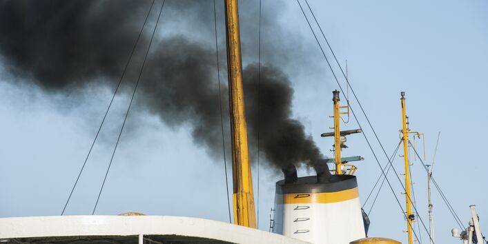 aus dem Schiffsschornstein quillt schwarzer Rauch 