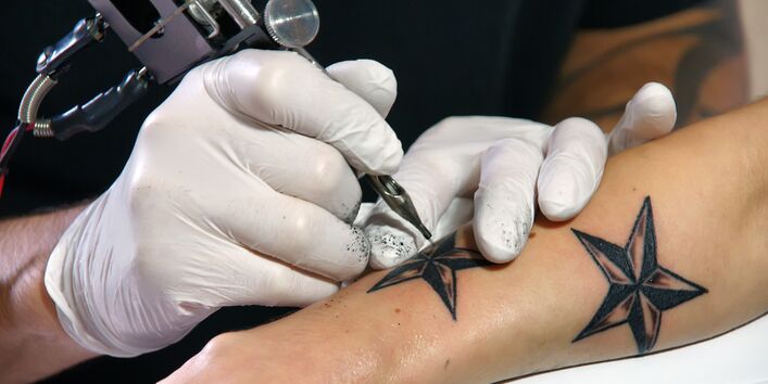 Titelbild UMID 01/2016: Auf dem Arm wird eine Tätowierung angebracht.