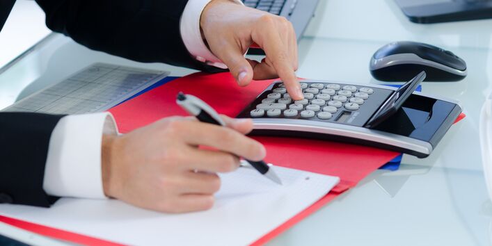 A man with the calculator calculates the costs.
