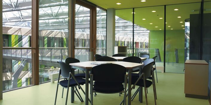 Besprechungsraum mit Tisch und Stühlen, ausgelegt mit elastischem Fußbodenbelag