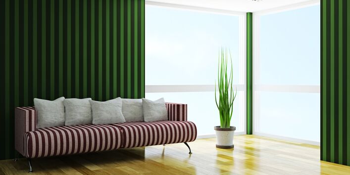 Ein rot-weiß gesteiftes Sofa steht in einem hellen Raum.