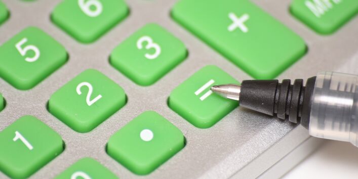 grüne Tasten eine Taschenrechners, wobei ein Kugelschreiber auf = zeigt