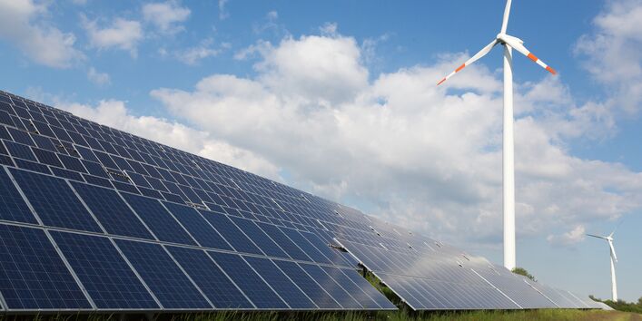 Windkraftanlagen und Solarpanels auf einer Wiese