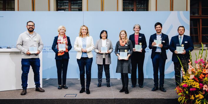 Die Ausgezeichneten des Papieratlas 2022 stehen mit Bundesumweltministerin Steffi Lemke auf einer Bühne.