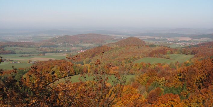 Landschaftsaufnahme von einer Erhebung hinunter in die Landschaft im Herbst.