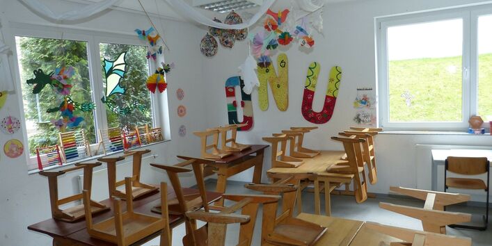 Wohnzimmer im Altbau mit Sofa, Tisch, Stehlampe, Bild und Pflanzen