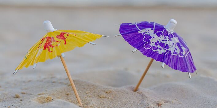 zwei kleine Papierhüte im Sand