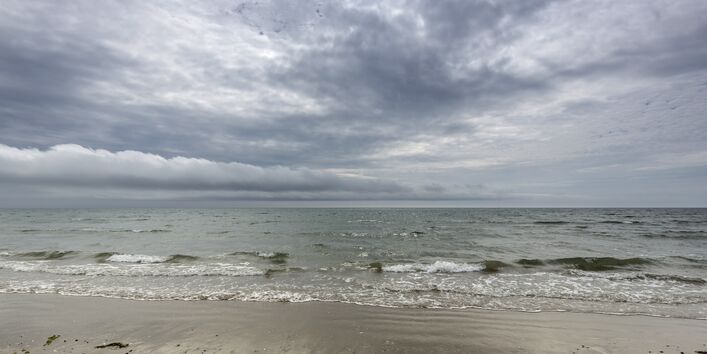 Ein Strand mit Wellen und Meer.
