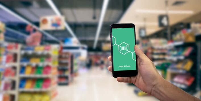 Eine Hand hält ein Smartphone in einem Geschäft