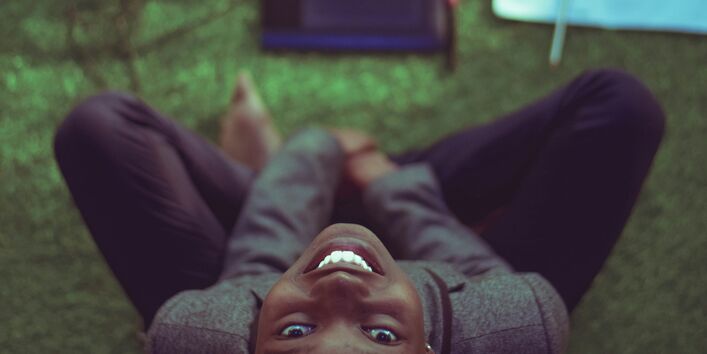 Eine Frau arbeitet am Laptop und blickt direkt nach oben