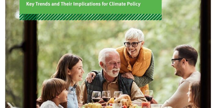 Menschen sitzen um einen gedeckten Tisch im Freien