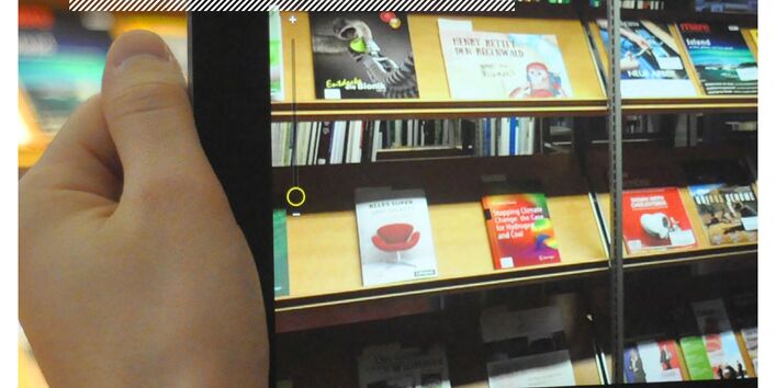 Foto aus dem Lesesaal in Dessau vor dem Regal mit Neuerwerbungen