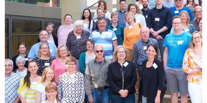 Menschen stehen auf einer Treppe und schauen in die Kamera