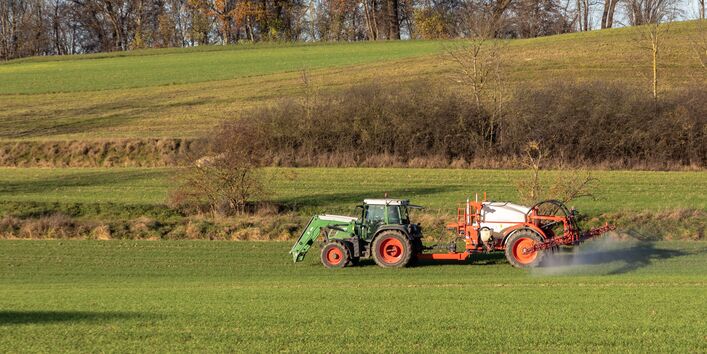 Traktor besprüht ein Feld
