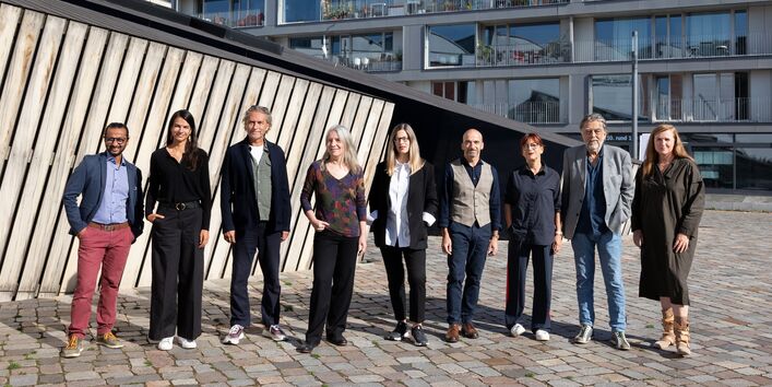 Die Jury steht vor einem Gebäude.