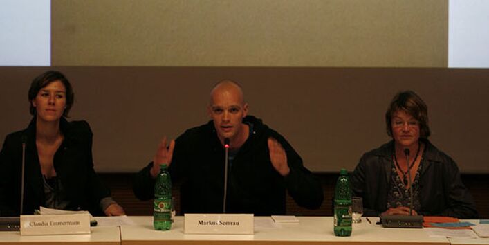 Mit erhobenen Händen spricht der Podiumsdiskutant Marcus Semrau zum Publikum.