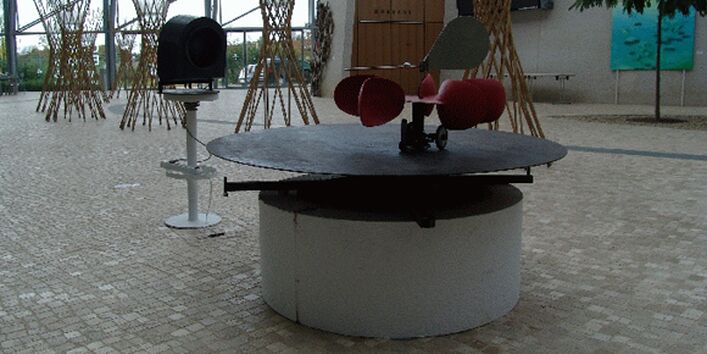 Konstrultion aus einer Drehscheibe auf der ein Sitz mit Rollen befestigt ist die es erschwert dort normal sitzen zu können