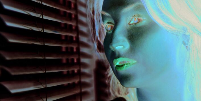 The picture shows a woman’s head and shoulders while she looks sceptically out of a window. The window is part-shaded by an indoor blind.