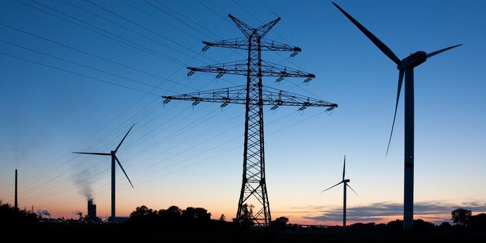 Stromstraße aus Windkraftanlagen in der Abenddämmerung