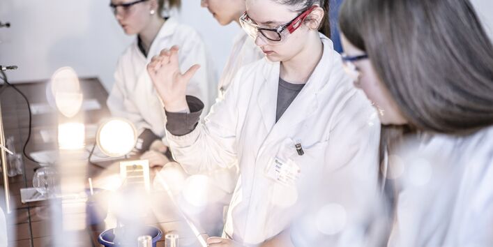 Ein Foto im Labor mit mehreren Mädchen, die sich für den Mädchen-Zukunftstag angemeldet haben, um einen Einblick in die Berufswelt zu erhalten. 